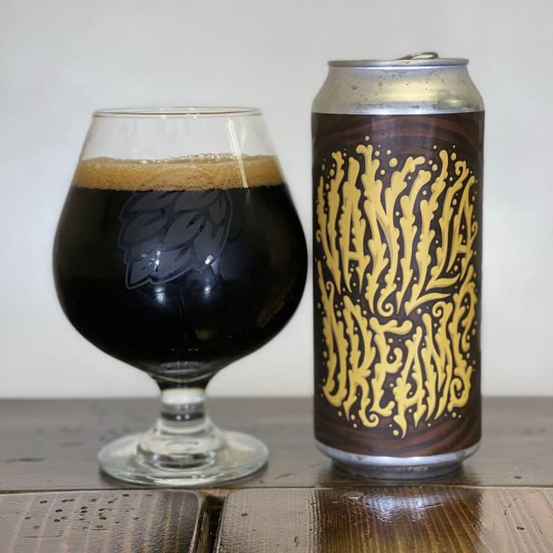 Glass filled with dark beer next to a can of Lululin Brewing Vanilla Dreams.