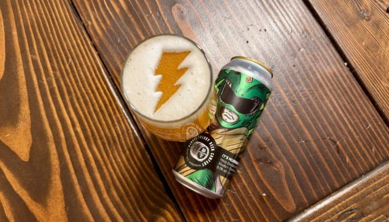 Can of Barrel Theory It's Morphin Time next to a glass of beer with the Power Ranger logo in the foam.