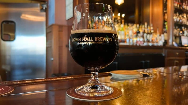 A snifter glass of barrel aged beer on the bar at Minneapolis Town Hall Brewery.